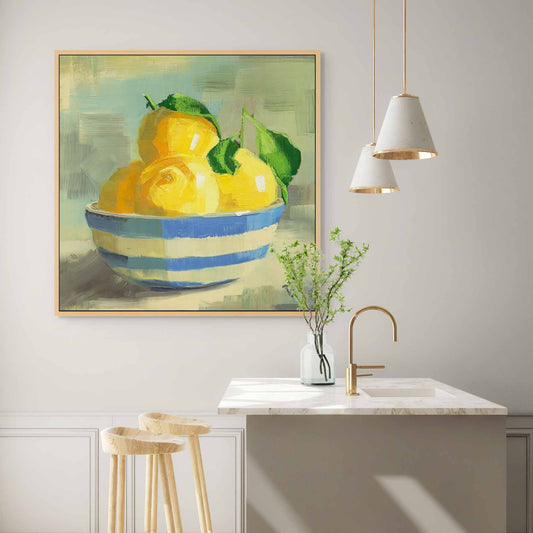 Framed artwork of lemons in a bowl on a wall above a kitchen sink.