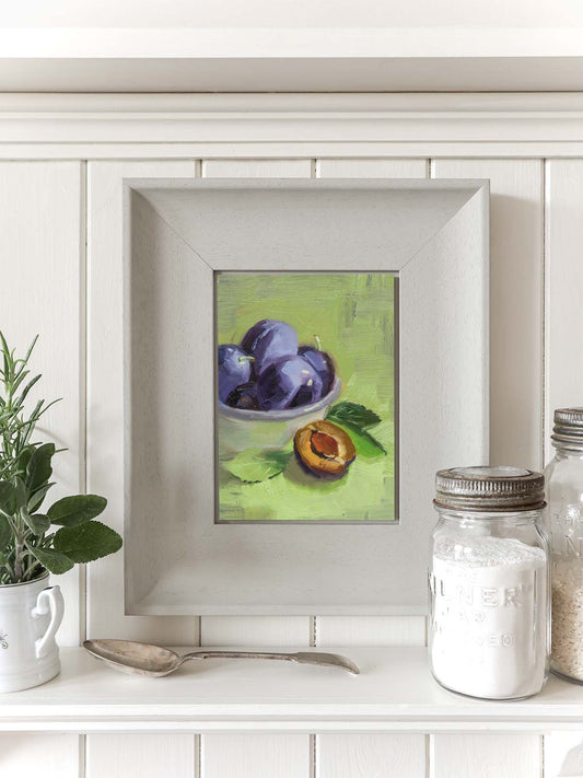 Purple plums in white enamel bowl on green background, small kitchen wall art.