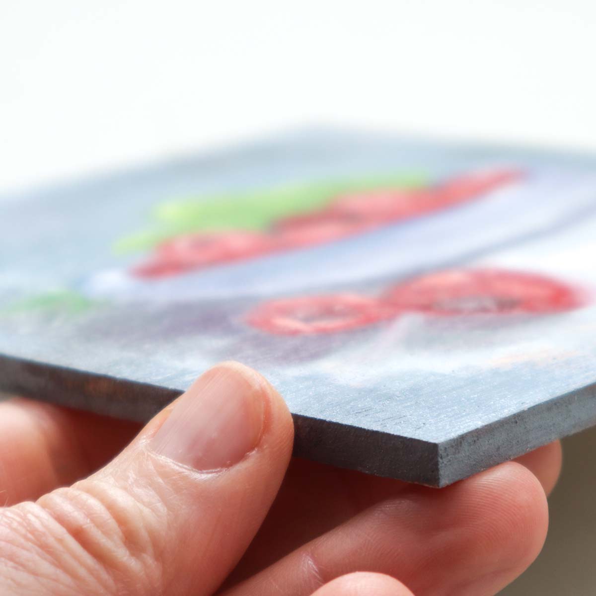 Side angle of raspberry artwork showing painting depth
