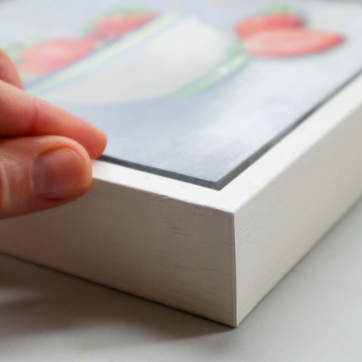 Side view of strawberry painting showing white tray frame depth and quality finish
