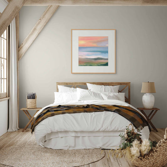 Framed artwork of sunset on wall above master bed in a cozy bedroom with wooden and white decoration.