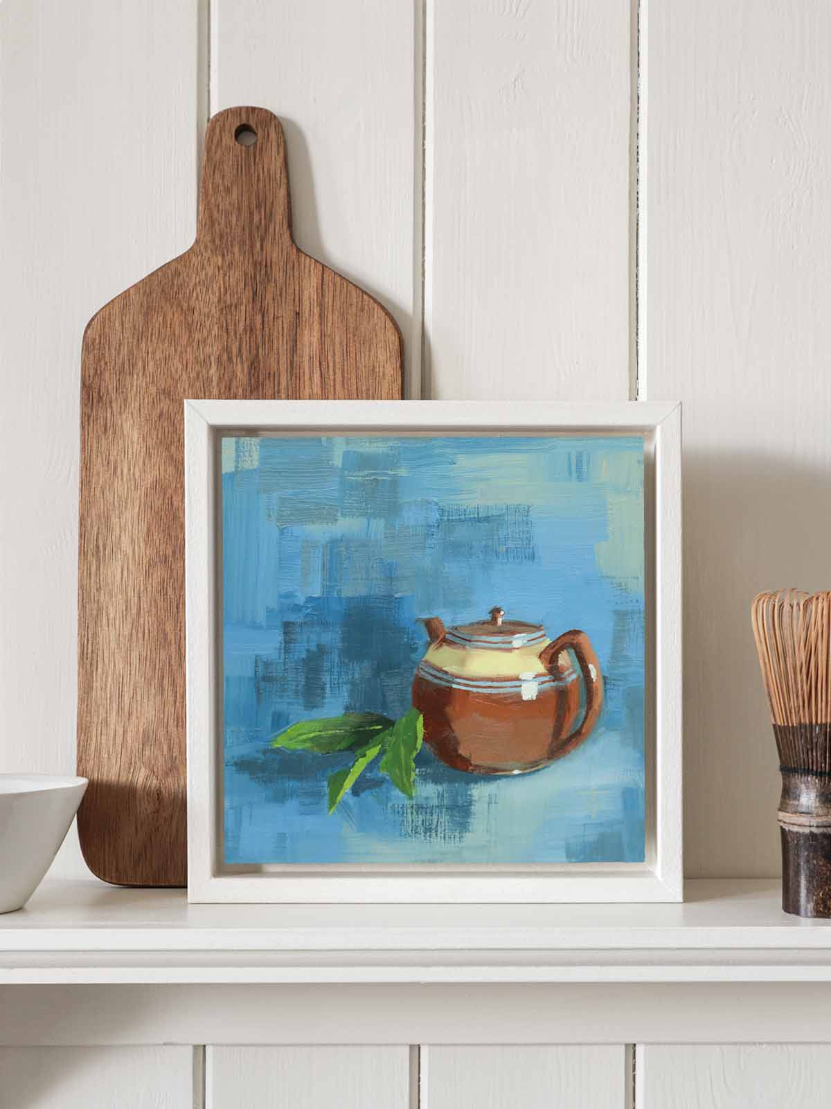 Vintage brown teapot painting in white tray frame displayed on kitchen shelf