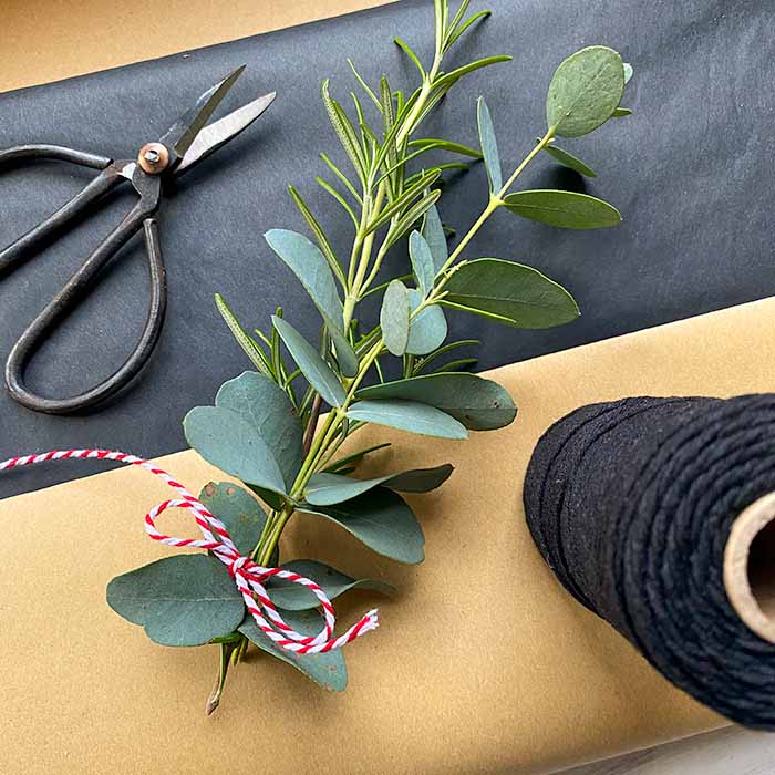 Close up of carefully wrapped oil painting with fresh rosemary and eucalyptus, ready for safe delivery.