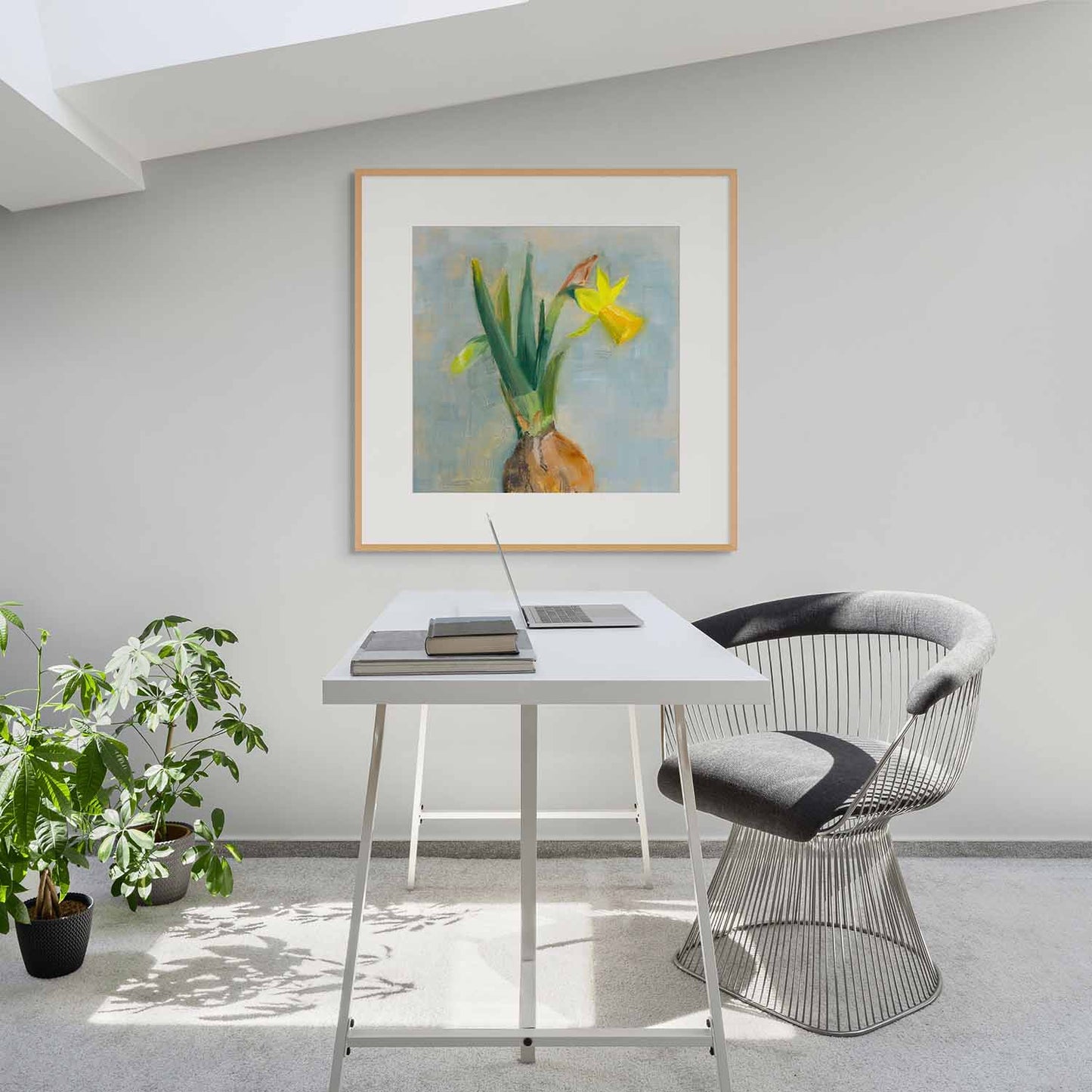 Modern office setup with a desk, chair, and framed artwork on a wall.