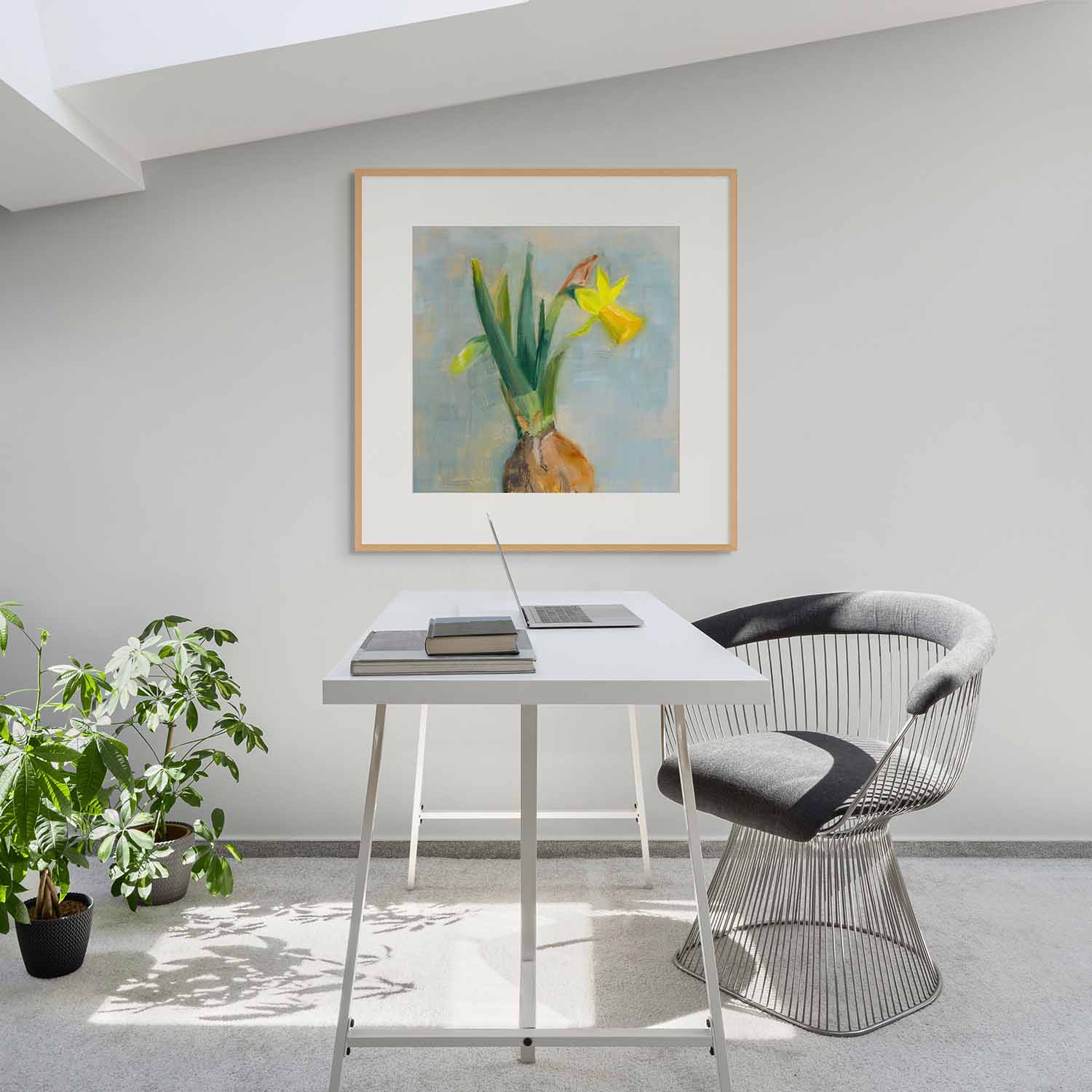 Modern office setup with a desk, chair, and framed artwork on a wall.