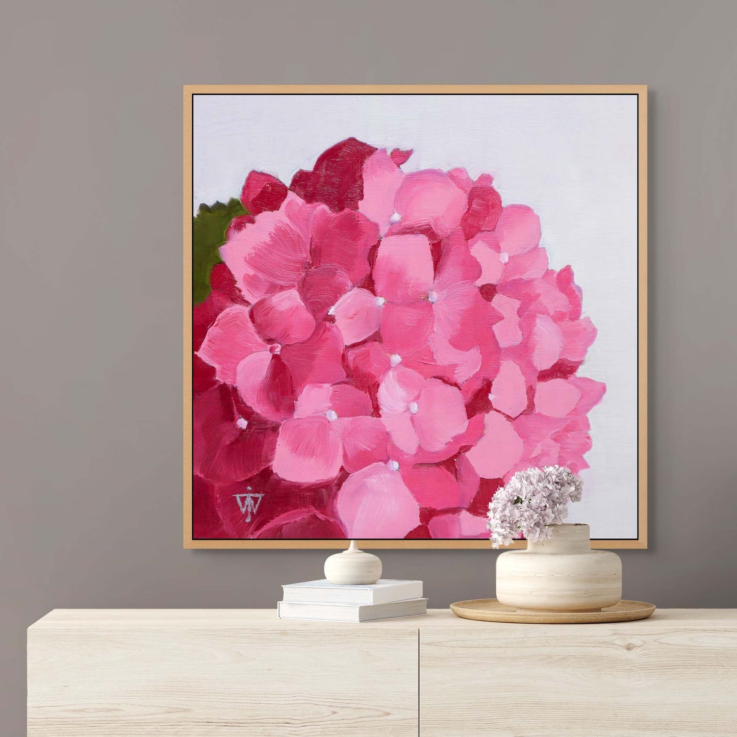 Flower painting wall art in oak floater frame on grey wall above sideboard.