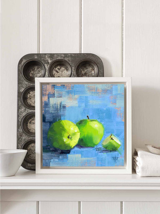 Apple painting in white tray frame displayed on kitchen shelf