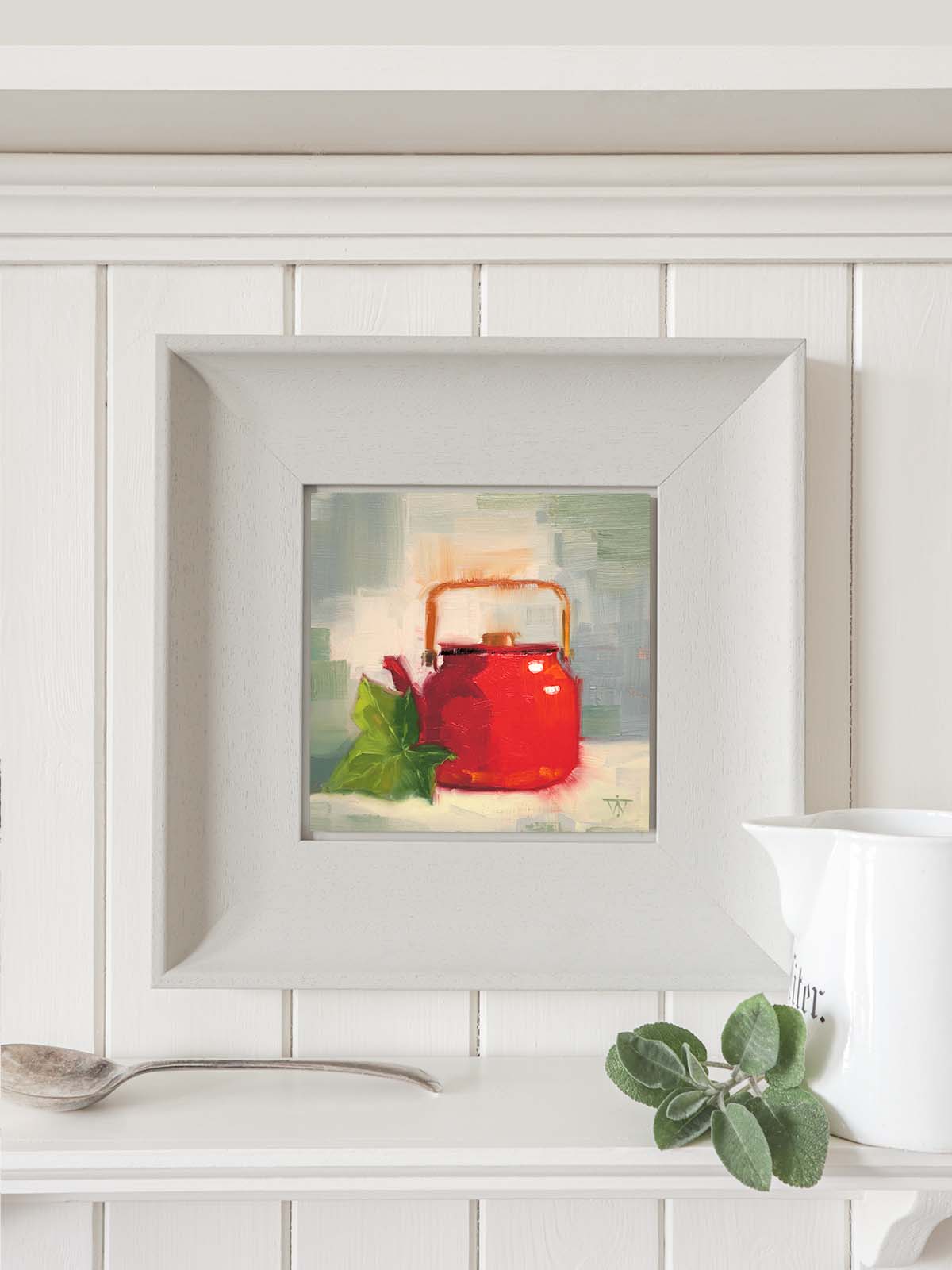 Red teapot with ivy painting in grey modern frame hanging on kitchen wall