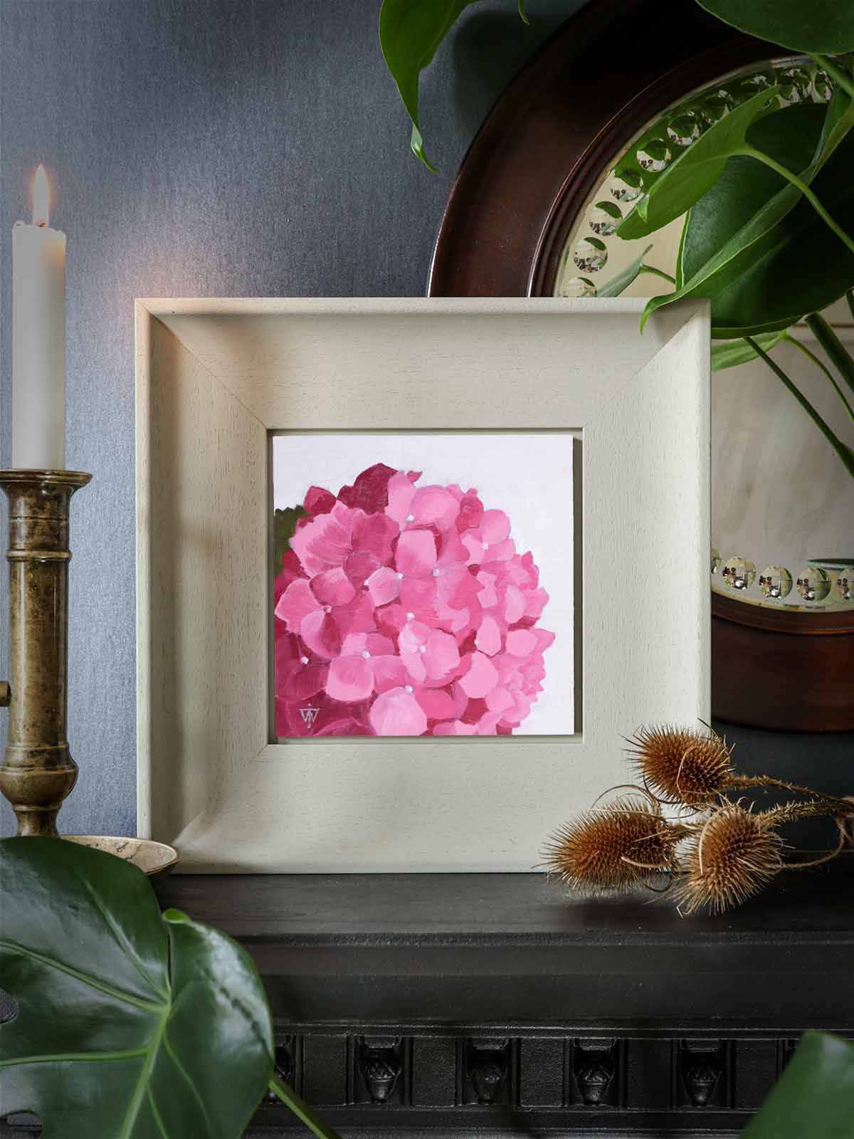 Pink hydrangea flower on white background, styled on fireplace mantle in living room.