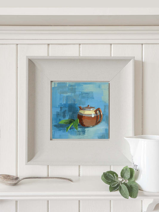Vintage brown teapot painting in modern grey frame hanging on kitchen wall