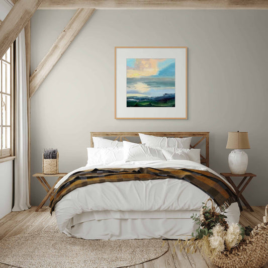 Artwork for nature, sky and sea in a cozy bedroom displayed above a wooden bed with side tables.