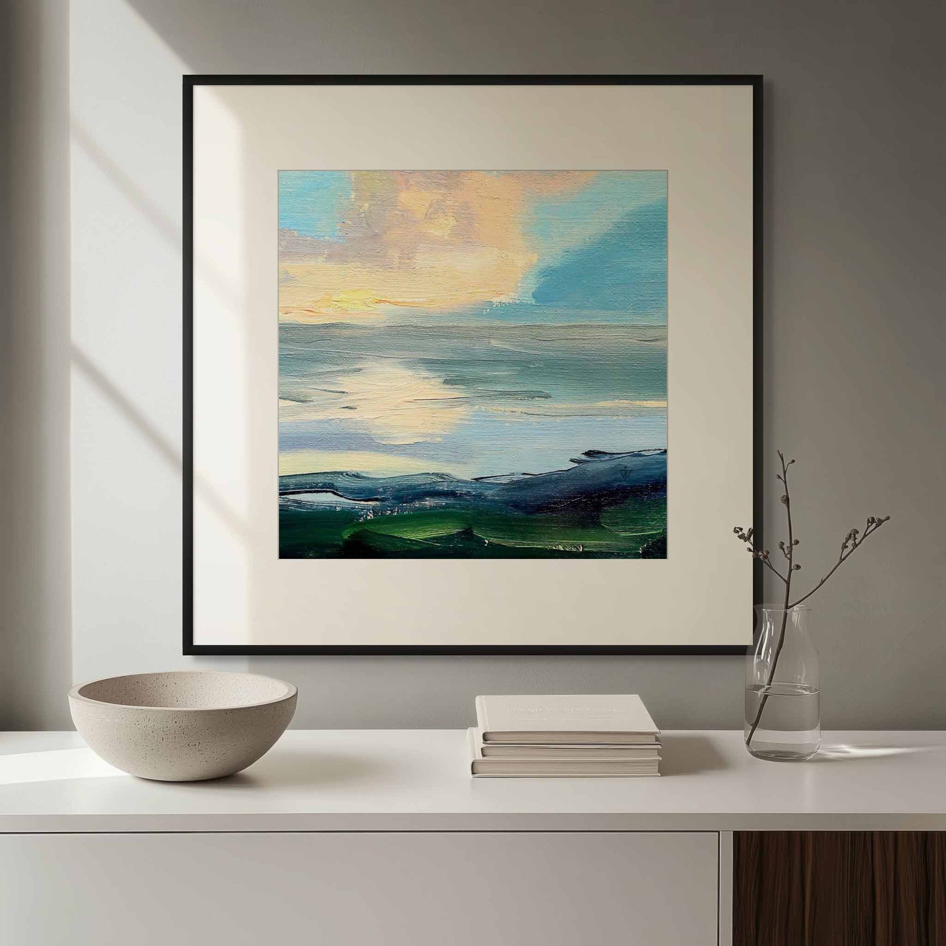 Framed abstract landscape painting on a wall above a white console table with decorative items.