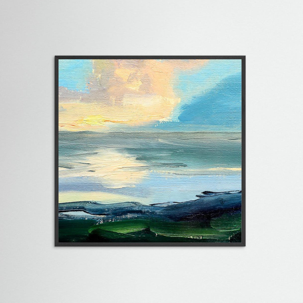Framed artwork of a landscape with a sunset over water on a white wall.