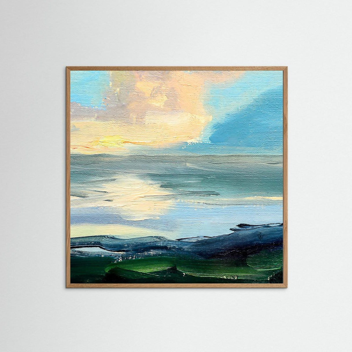 Framed artwork of a landscape with a big cloud over water on a white wall.