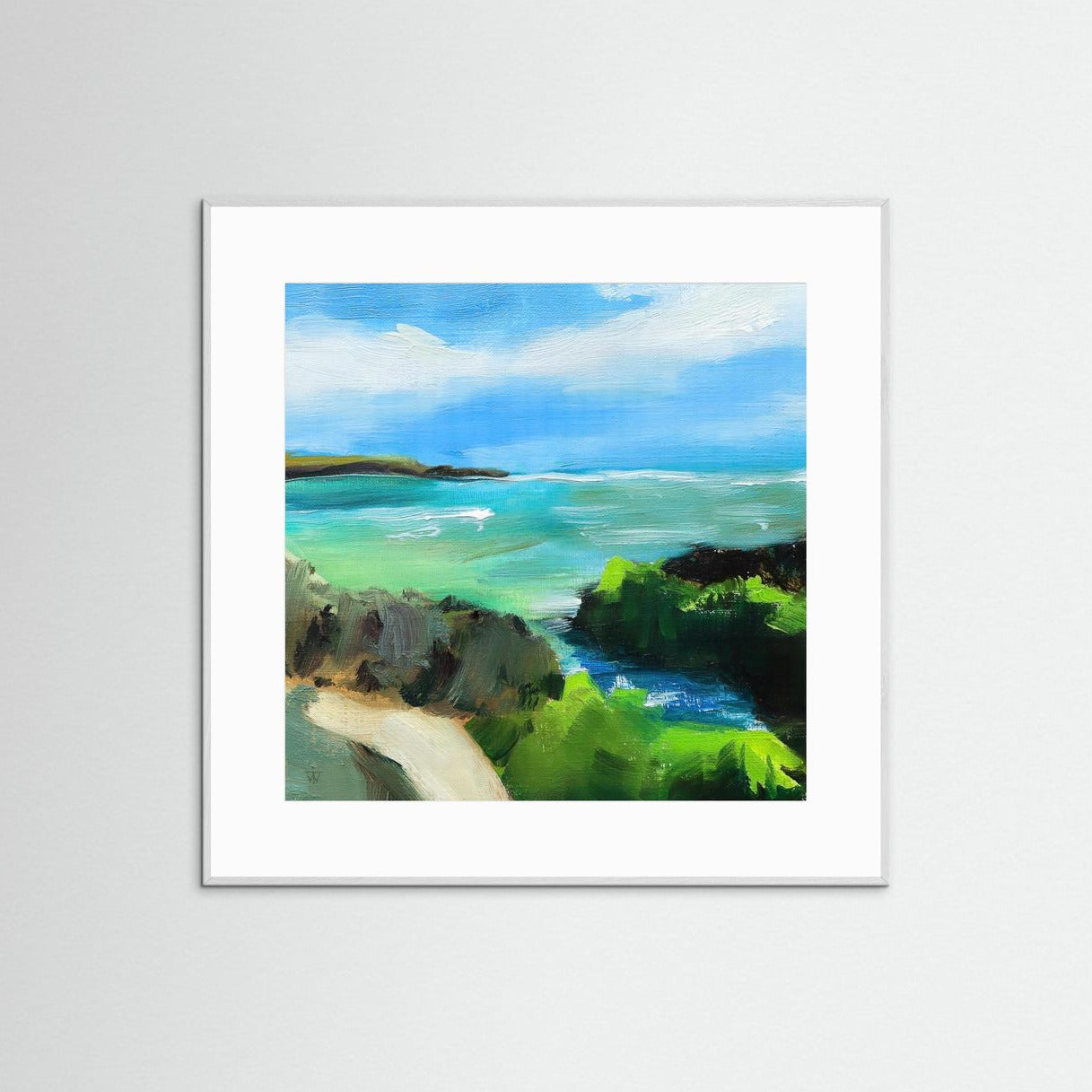 Framed painting with vibrant blue sky, green cliffs and turquoise sea in white frame on white wall